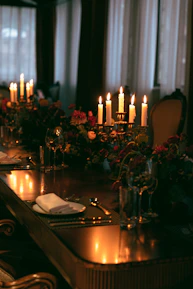 A beautifully set candlelit dining table in an intimate private room, ready for a gathering.