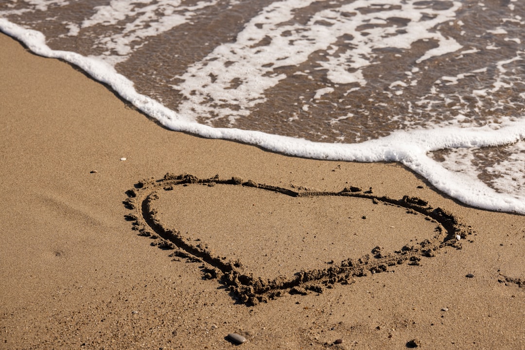 brown sand with water waves during daytime