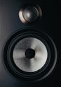 black and gray speaker on brown wooden table