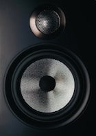 black and gray speaker on brown wooden table