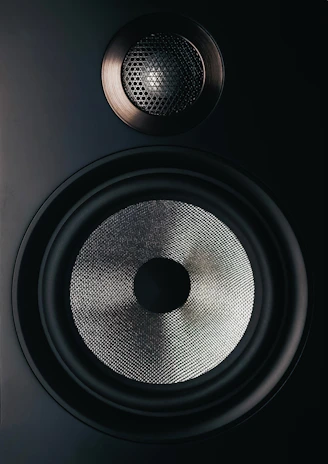 black and gray speaker on brown wooden table