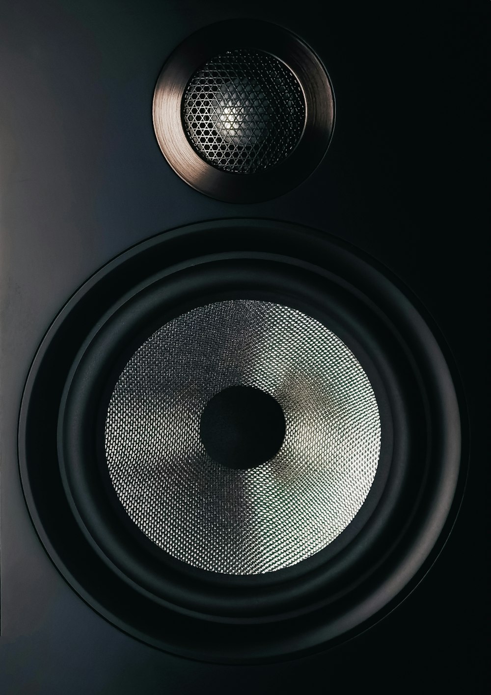 schwarz-grauer Lautsprecher auf braunem Holztisch