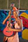 woman in red halter top playing brown acoustic guitar
