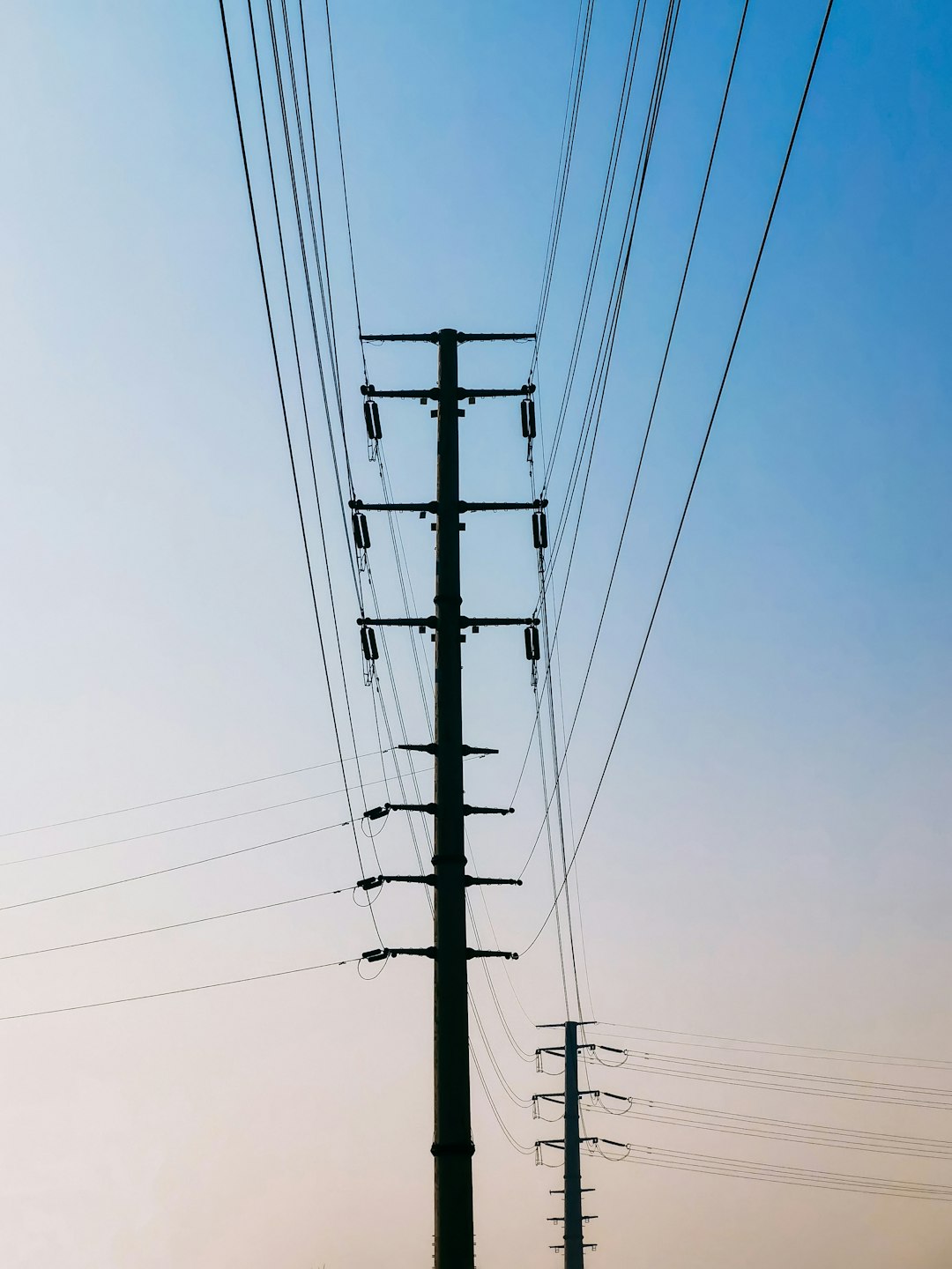 black electric post under blue sky during daytime
