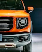 Close-up of a sleek black and orange vehicle wrap designed by Evidence Comunicação Visual.