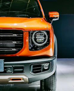 Close-up of RV’s sleek exterior with bright orange accents and rounded corners.