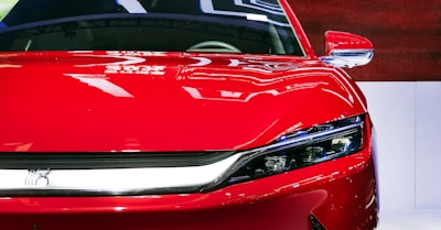 A clean vehicle exterior with bold red and dark gray colors gliding through city streets.