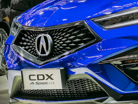 Close-up of a white car's front grille with blue and yellow lighting effects.