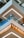 Detailed view of modern architectural elements featuring multiple floors of a building with stylish glass railings. The design includes distinctive geometric patterns and integrated lighting. The clean lines and contrasting colors add to the contemporary aesthetic.