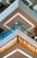 Detailed view of modern architectural elements featuring multiple floors of a building with stylish glass railings. The design includes distinctive geometric patterns and integrated lighting. The clean lines and contrasting colors add to the contemporary aesthetic.