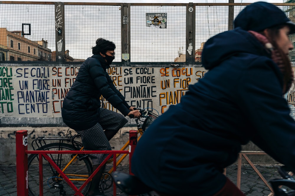 man in black jacket riding red bicycle