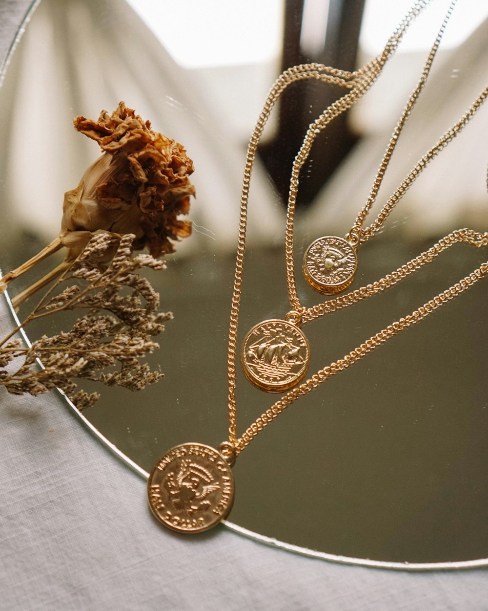 gold necklace on white textile