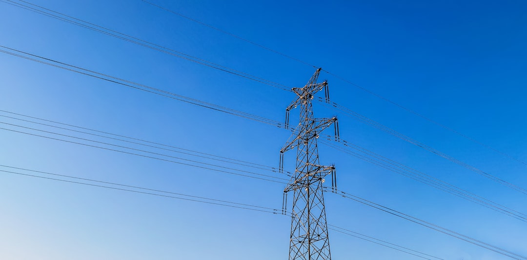 black electric post under blue sky during daytime