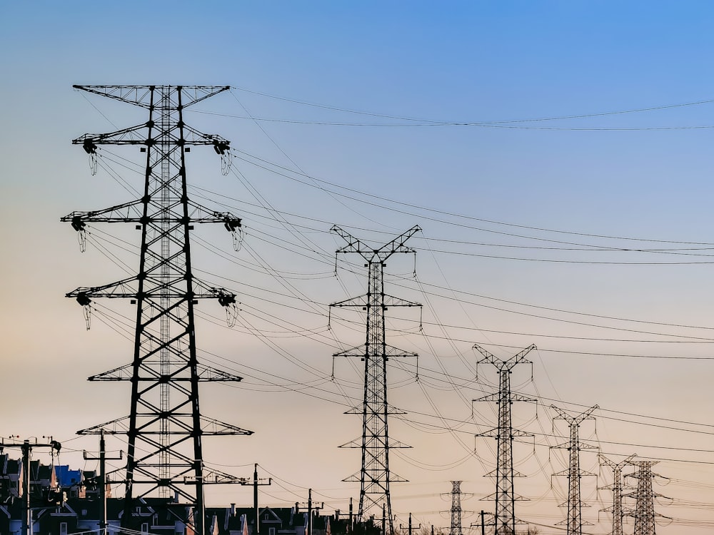 poste elétrico preto sob o céu azul durante o dia