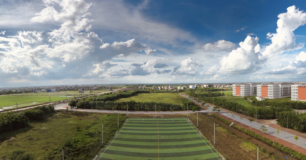 green field under blue sky and white clouds during daytime