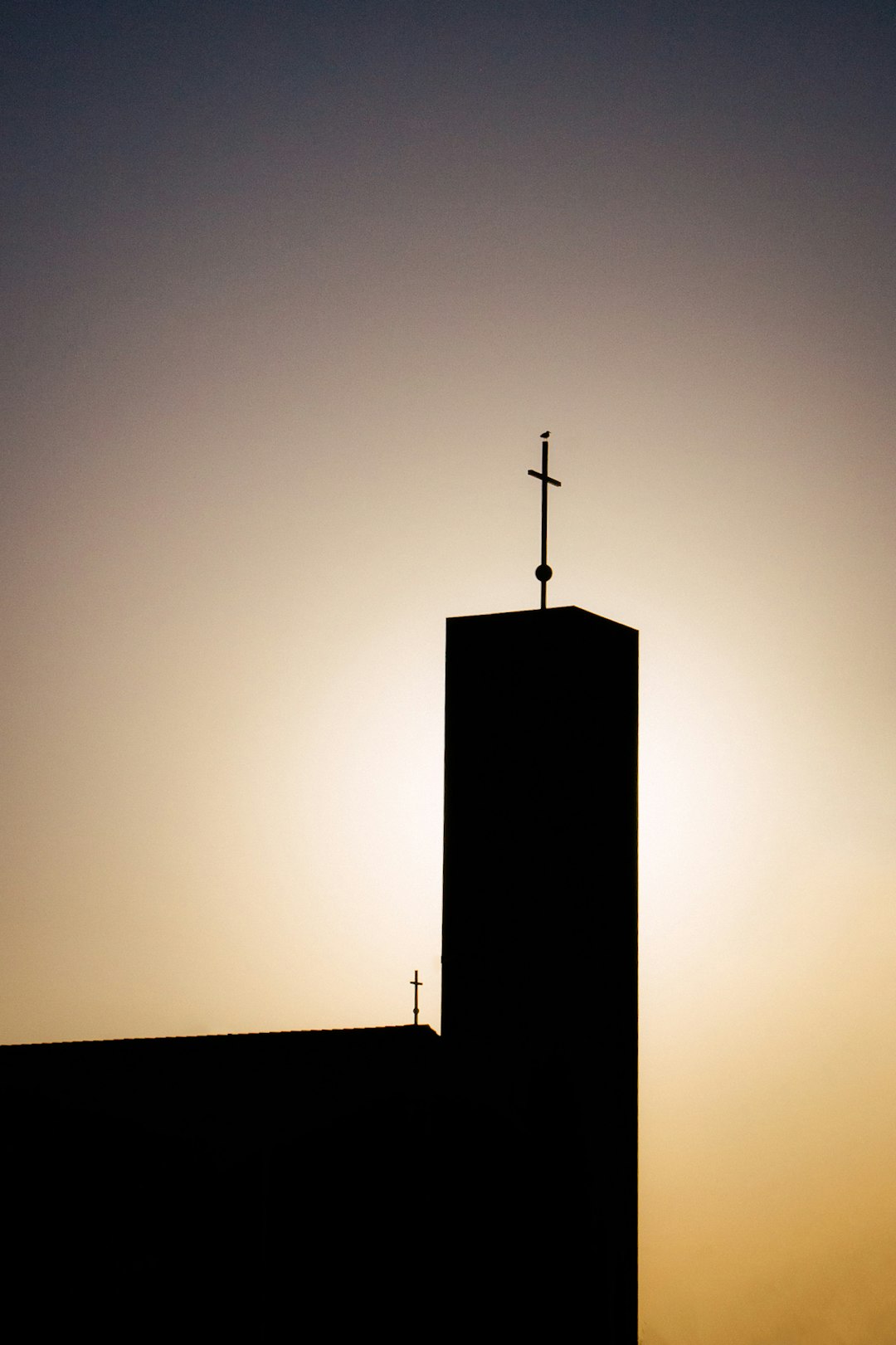 silhouette of cross on top of building