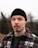 man in black knit cap and black red and white plaid jacket