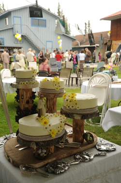 A vibrant cake display at a friendly community event, with people smiling and enjoying together.
