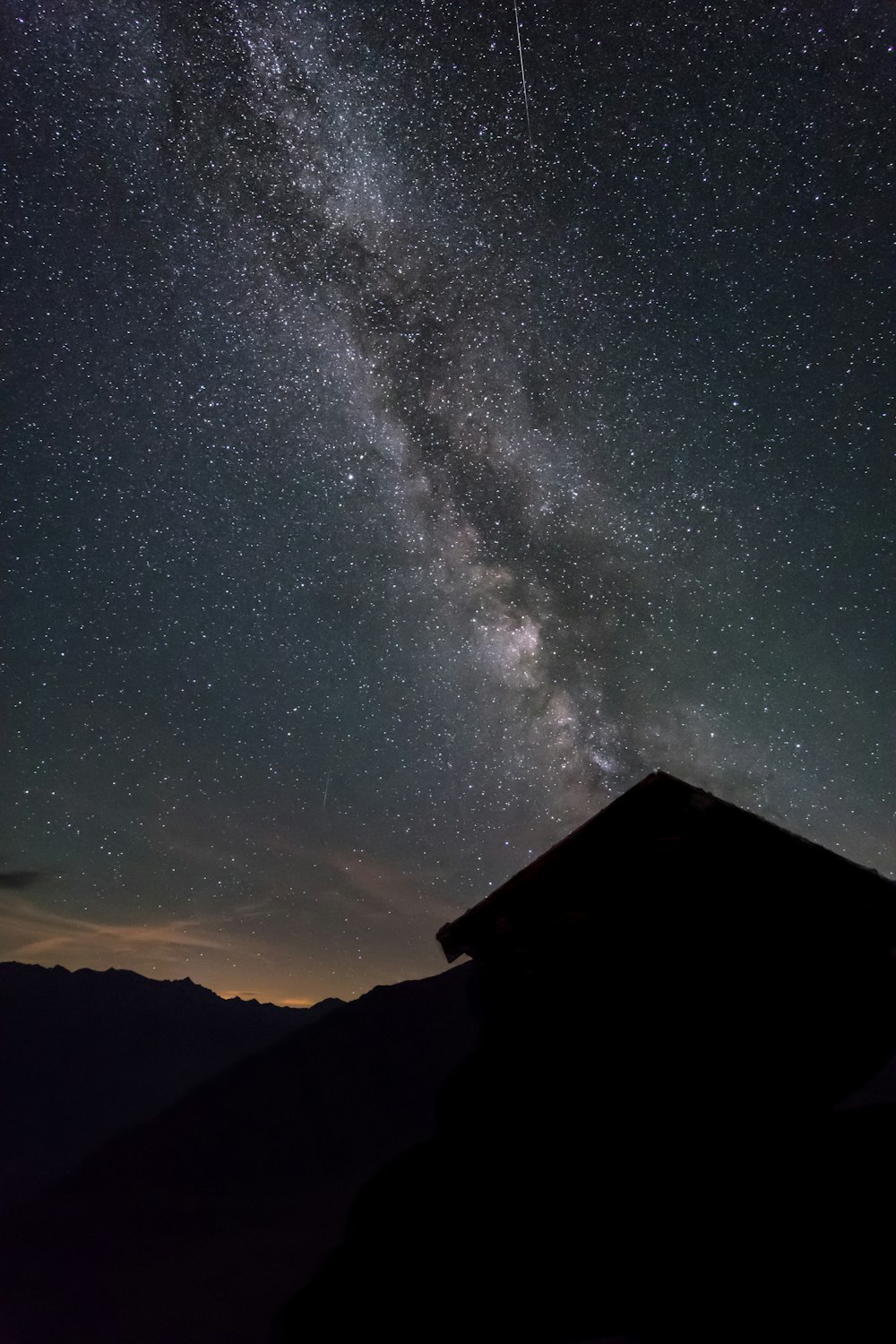 silhouette of house under starry night