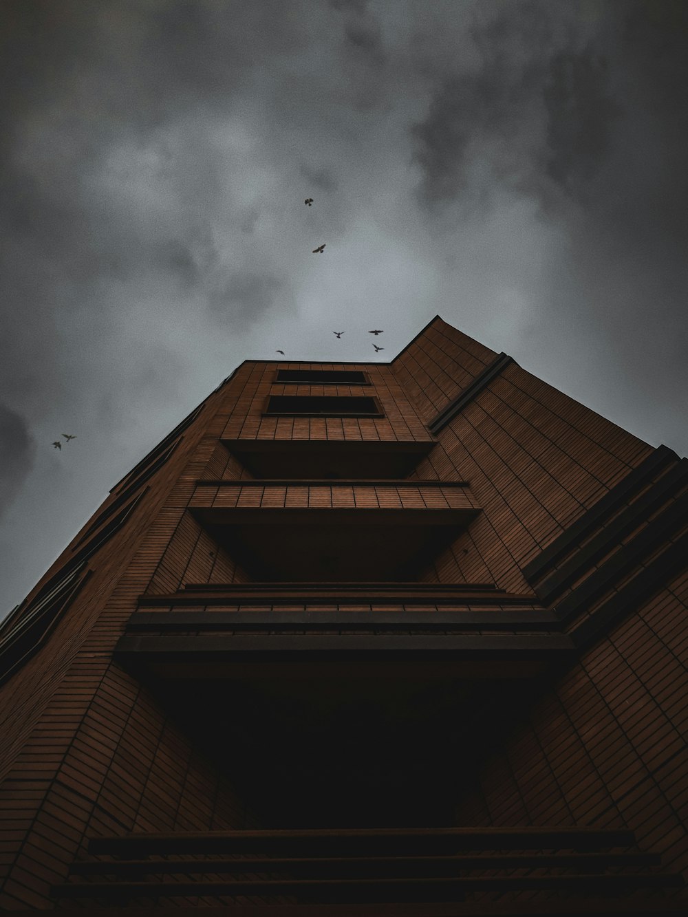 brown concrete building under gray clouds