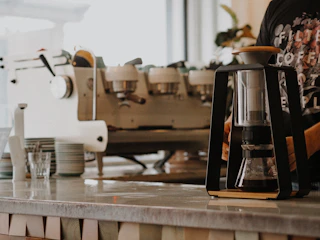 white and silver coffee maker on brown wooden table