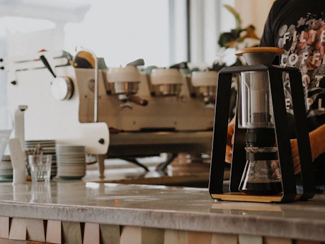 white and silver coffee maker on brown wooden table