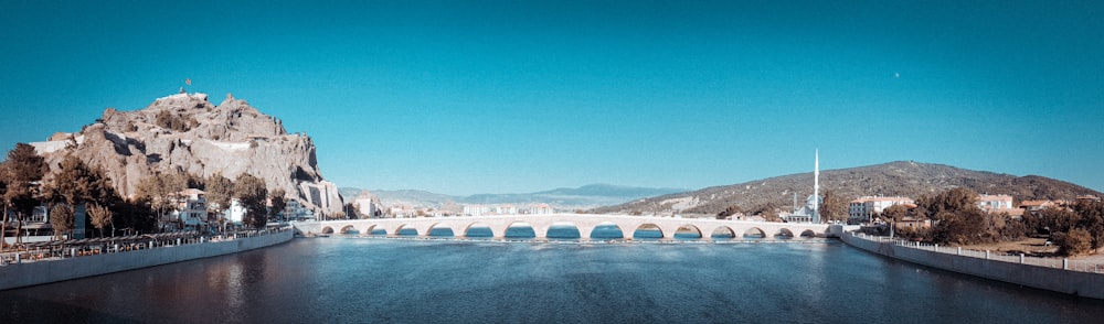 white concrete bridge over river under blue sky during daytime