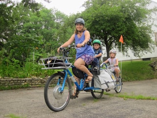 3 women riding on blue bicycles during daytime