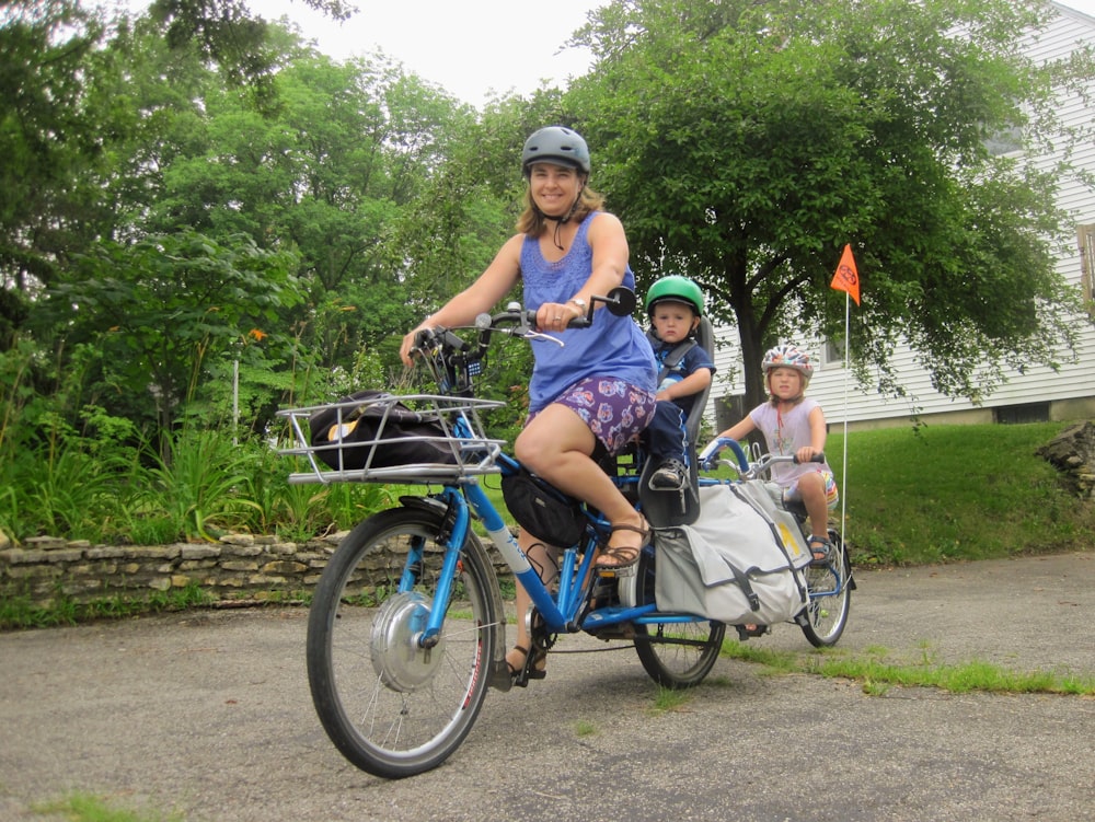 3 mulheres andando em bicicletas azuis durante o dia