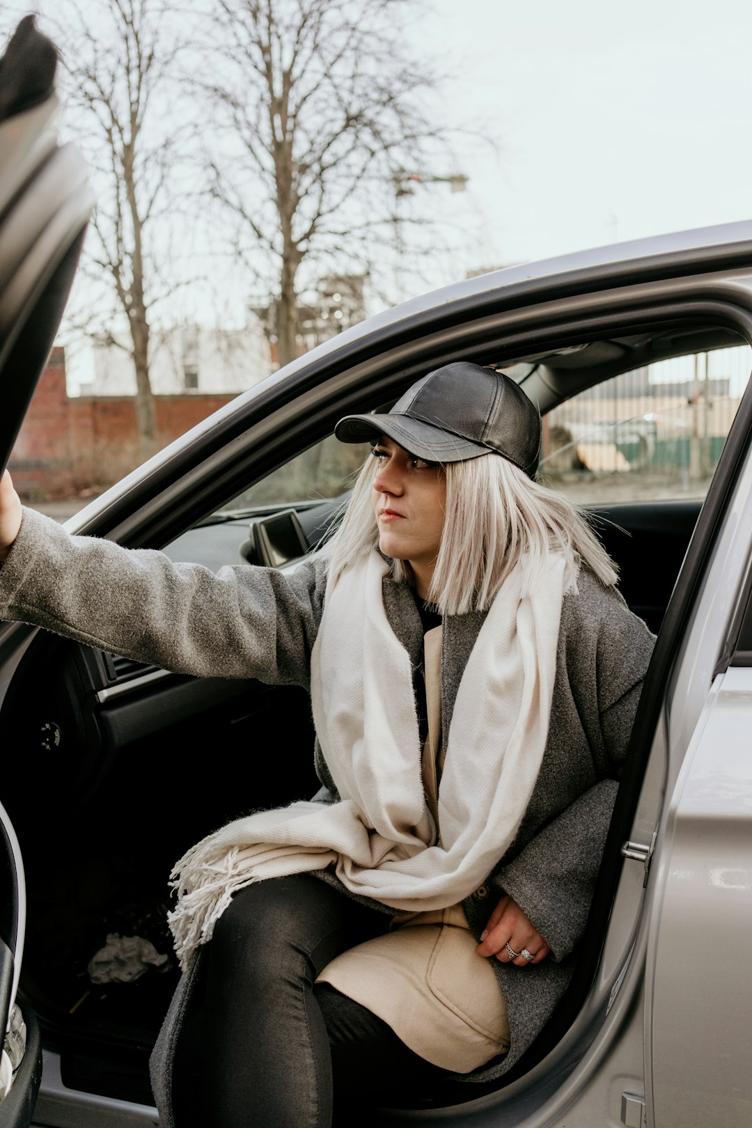 woman in gray coat and brown scarf sitting on car seat