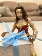 I-Woman action figure displayed with vibrant comic book backdrop.