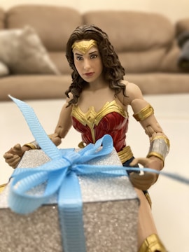 I-Woman action figure displayed with vibrant comic book backdrop.