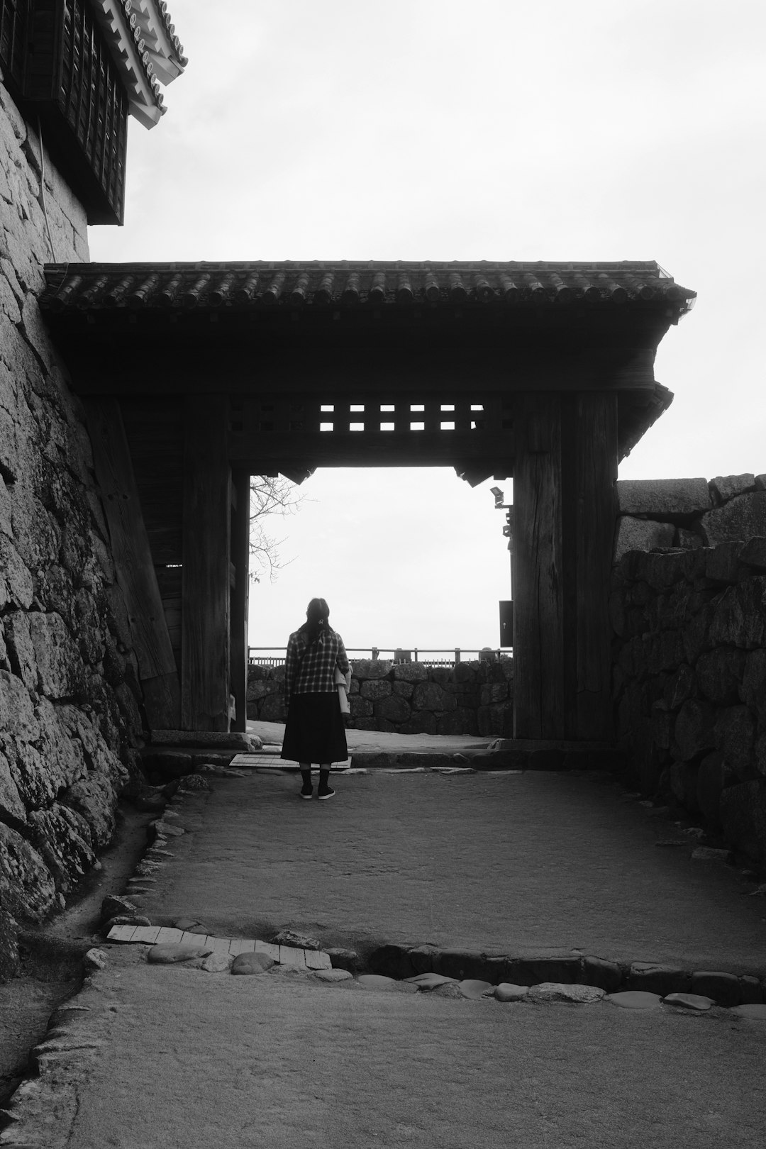 woman in black dress walking on tunnel