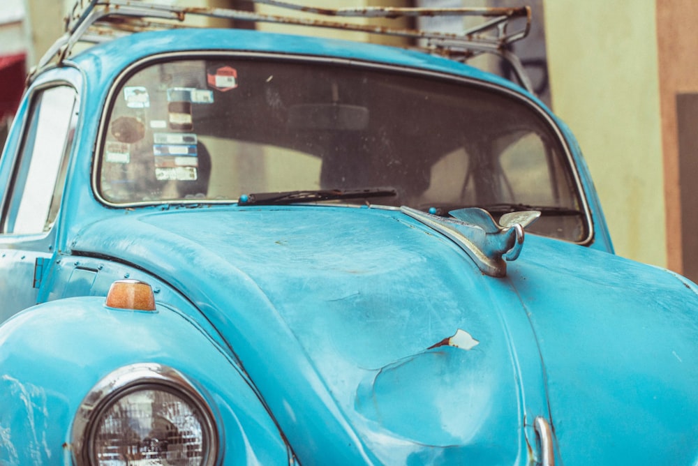 blue car parked beside white car during daytime