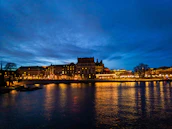 Cityscape of Asunción at dusk with warm lights and calm river.