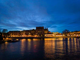 Cityscape of Asunción at dusk with warm lights and calm river.