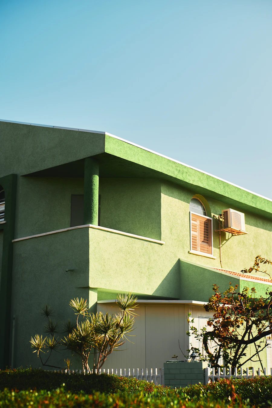 Casa real com fachada em verde-musgo vibrante e detalhes brancos