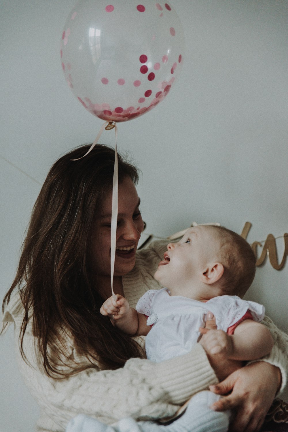 woman in white shirt carrying baby in white shirt