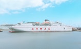 white and red ship on sea under blue sky during daytime