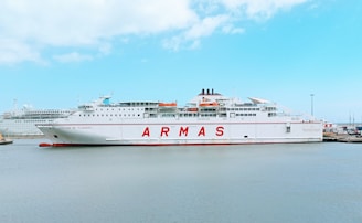 white and red ship on sea under blue sky during daytime