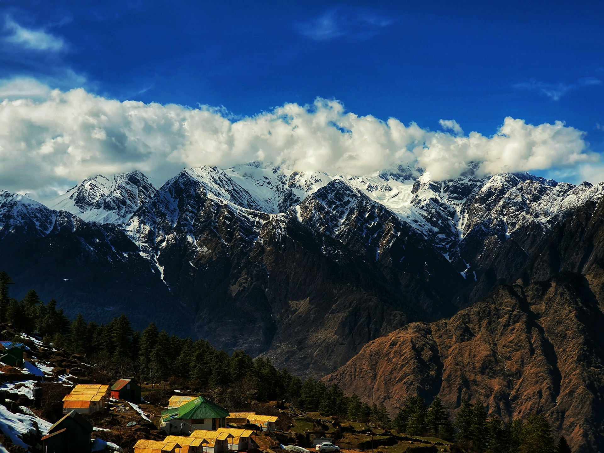 Panoramic view from cups n comfort’s window showcasing the majestic mountains surrounding Karimabad Hunza under a clear blue sky.