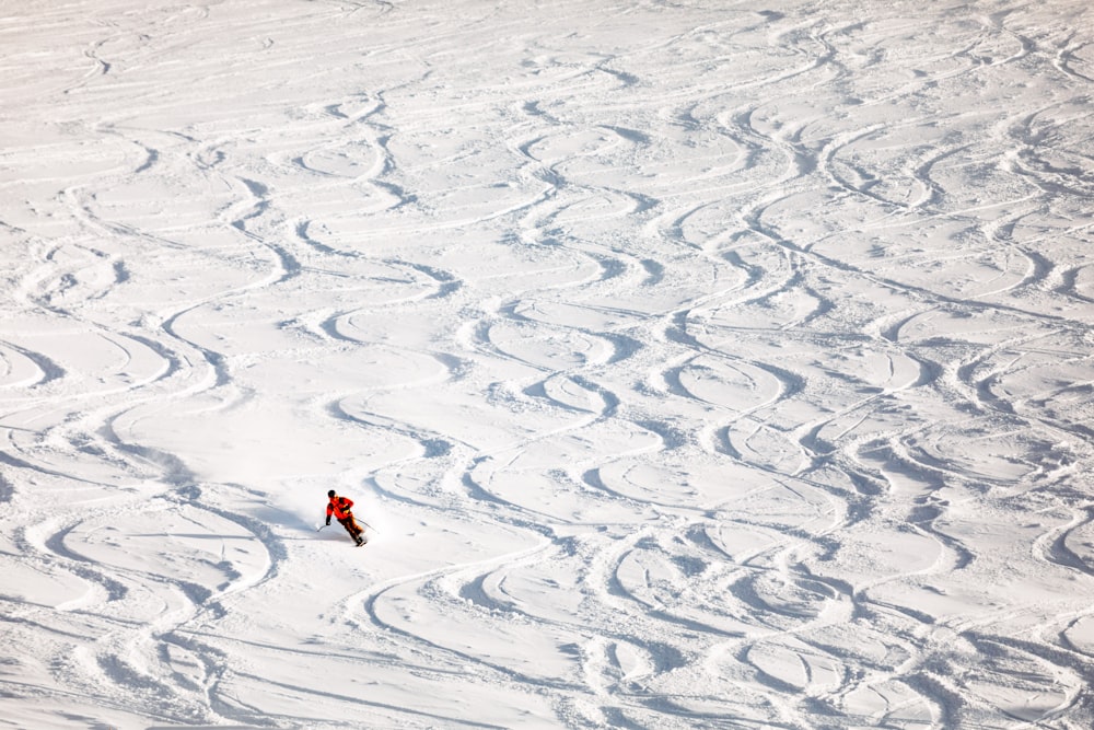 person in red shirt walking on white sand during daytime