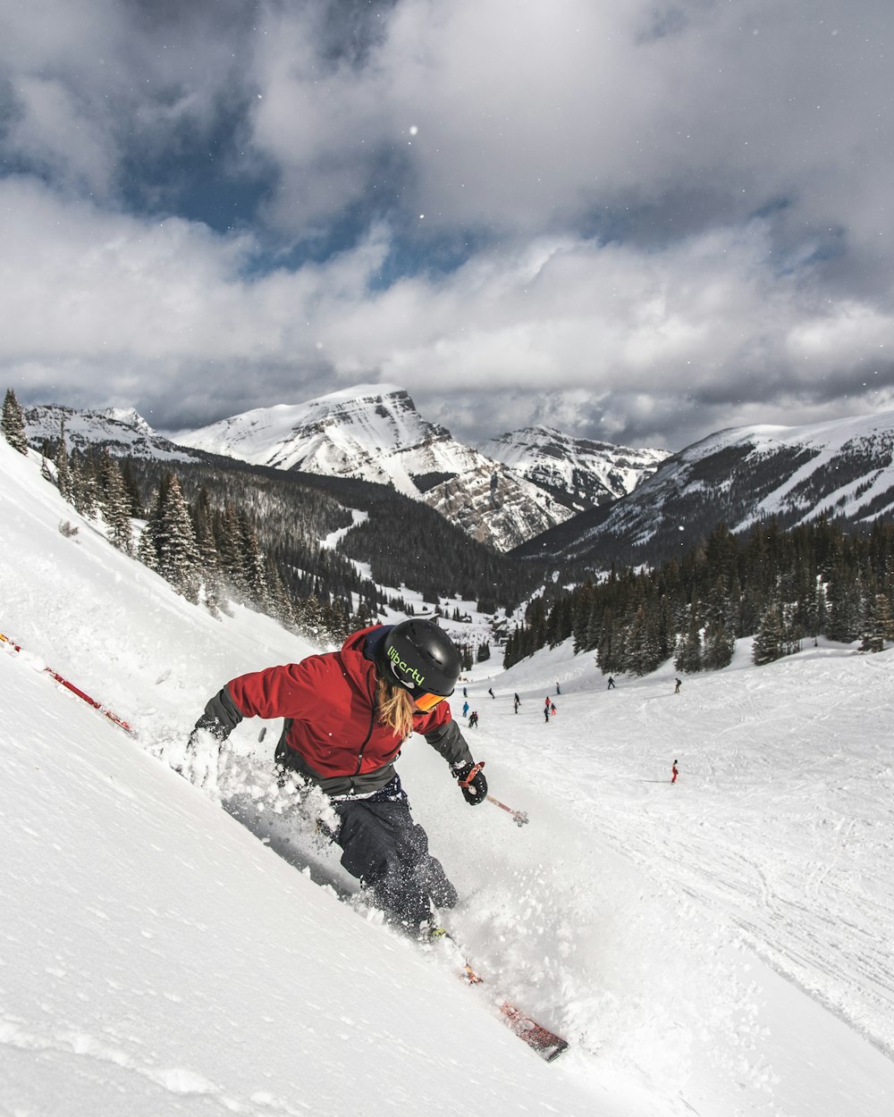 person in red jacket and black pants riding ski blades on snow covered mountain during daytime