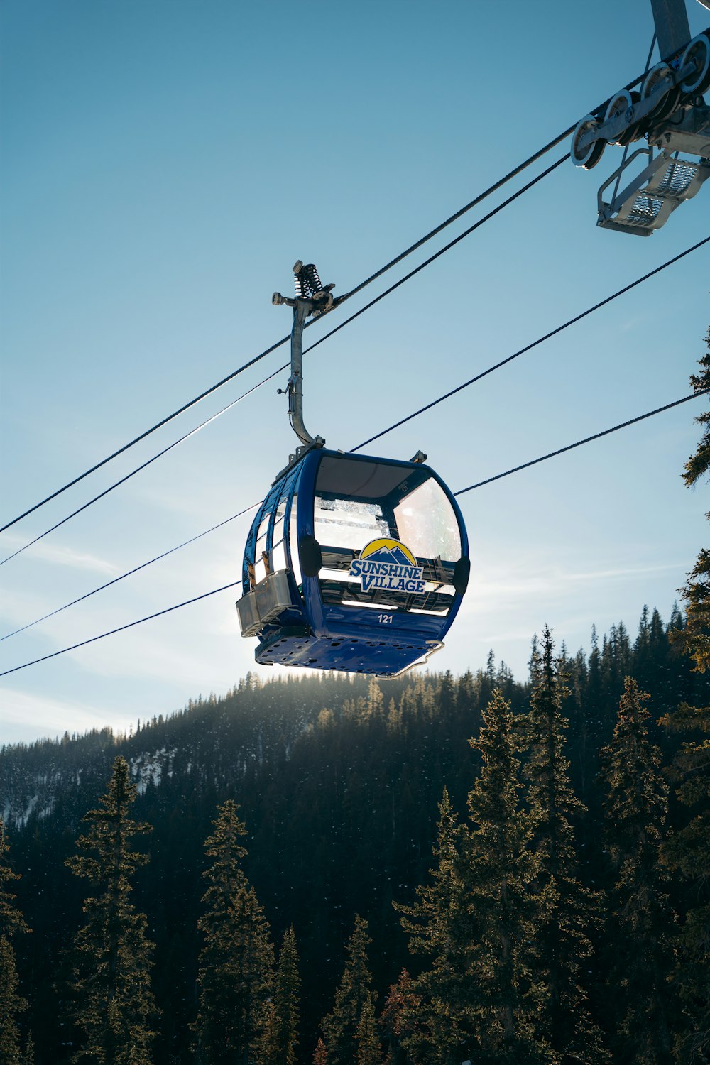 black cable car over green trees during daytime
