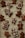A collection of homemade gingerbread cookies is laid out on a parchment-lined surface. Various shapes are decorated with white icing, including simple smiling gingerbread figures and elaborately designed patterns and swirls.