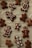 A collection of homemade gingerbread cookies is laid out on a parchment-lined surface. Various shapes are decorated with white icing, including simple smiling gingerbread figures and elaborately designed patterns and swirls.