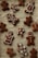 A collection of homemade gingerbread cookies is laid out on a parchment-lined surface. Various shapes are decorated with white icing, including simple smiling gingerbread figures and elaborately designed patterns and swirls.