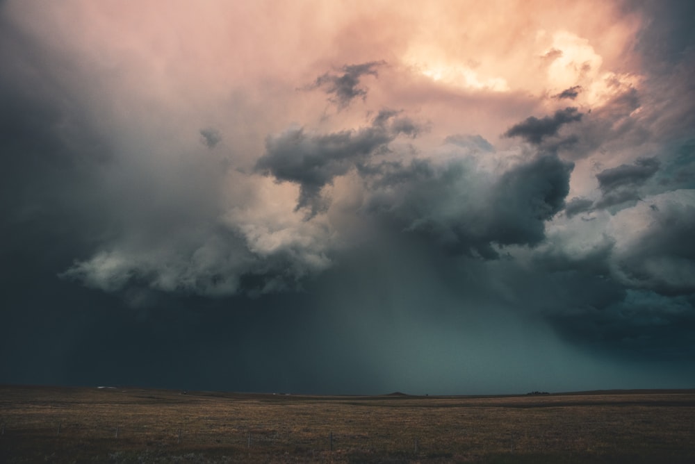 white clouds over brown field