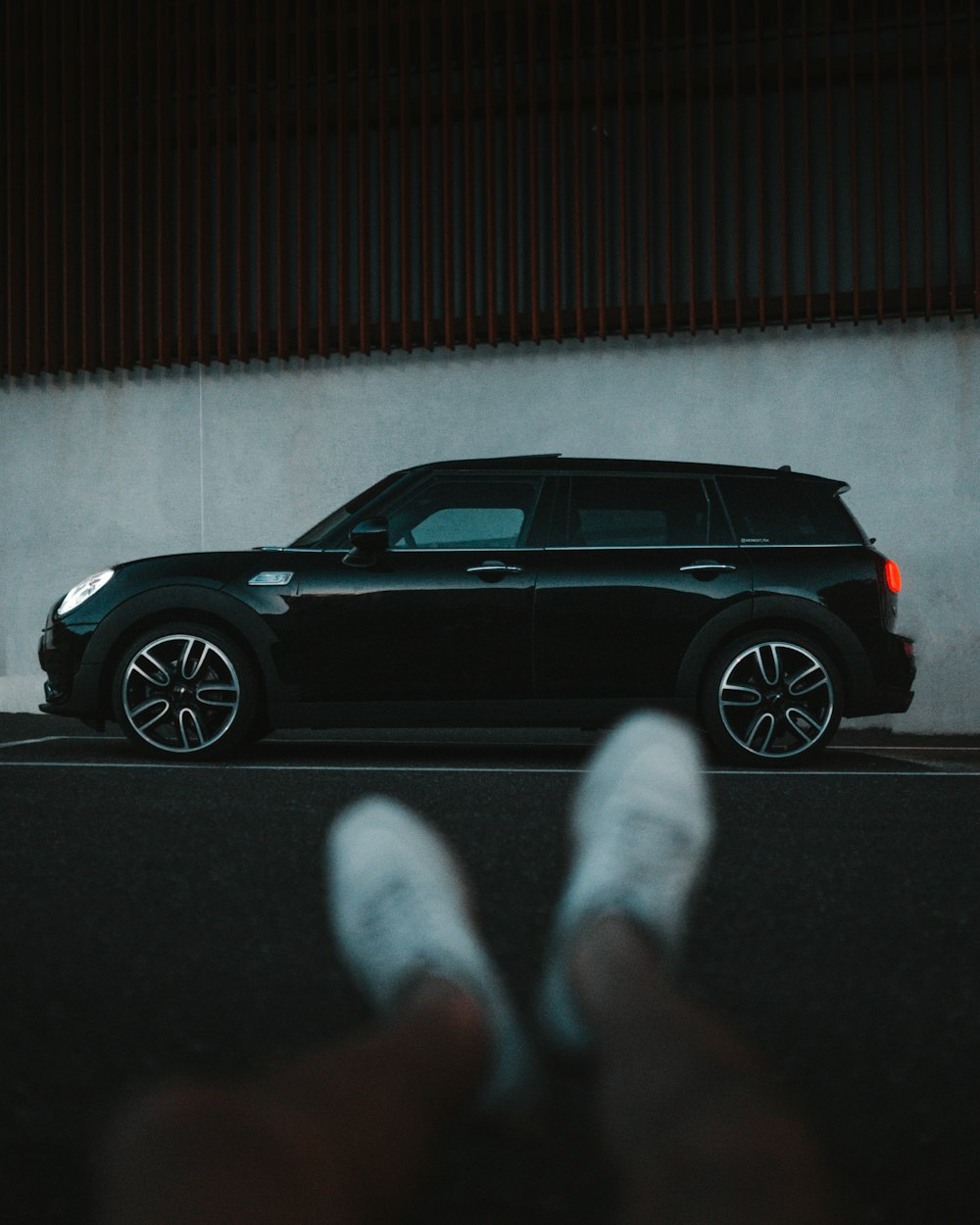 person in white pants and white socks standing beside black car