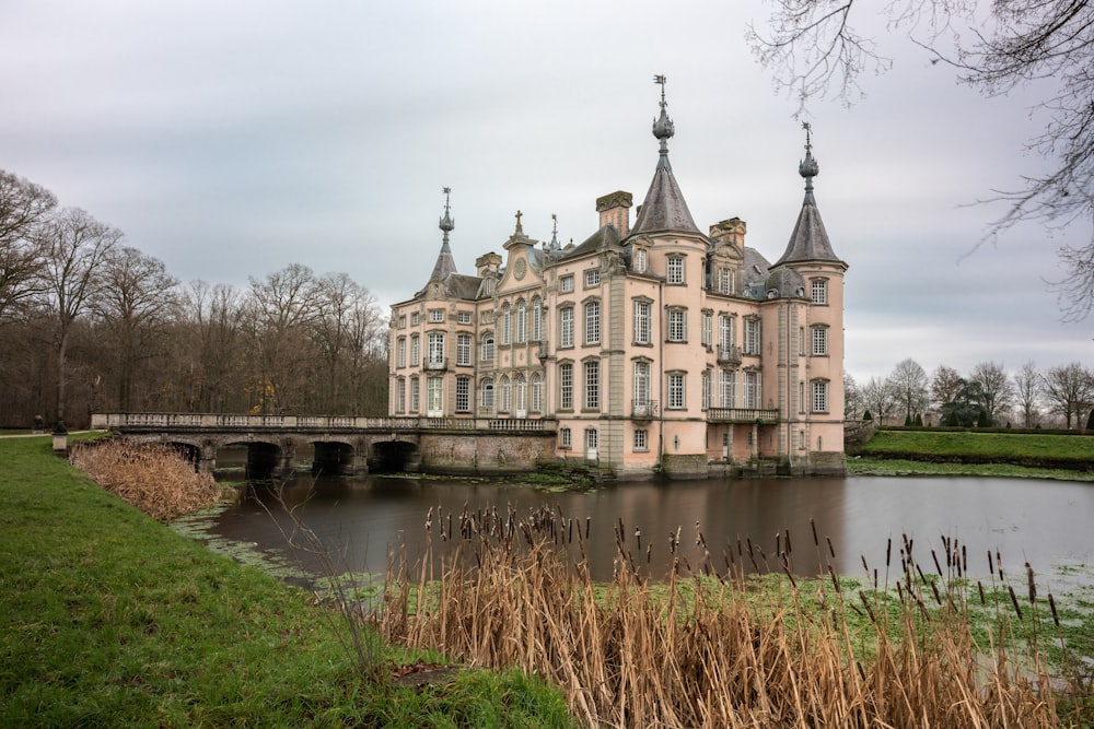 Bâtiment en béton brun et gris près d’un plan d’eau pendant la journée